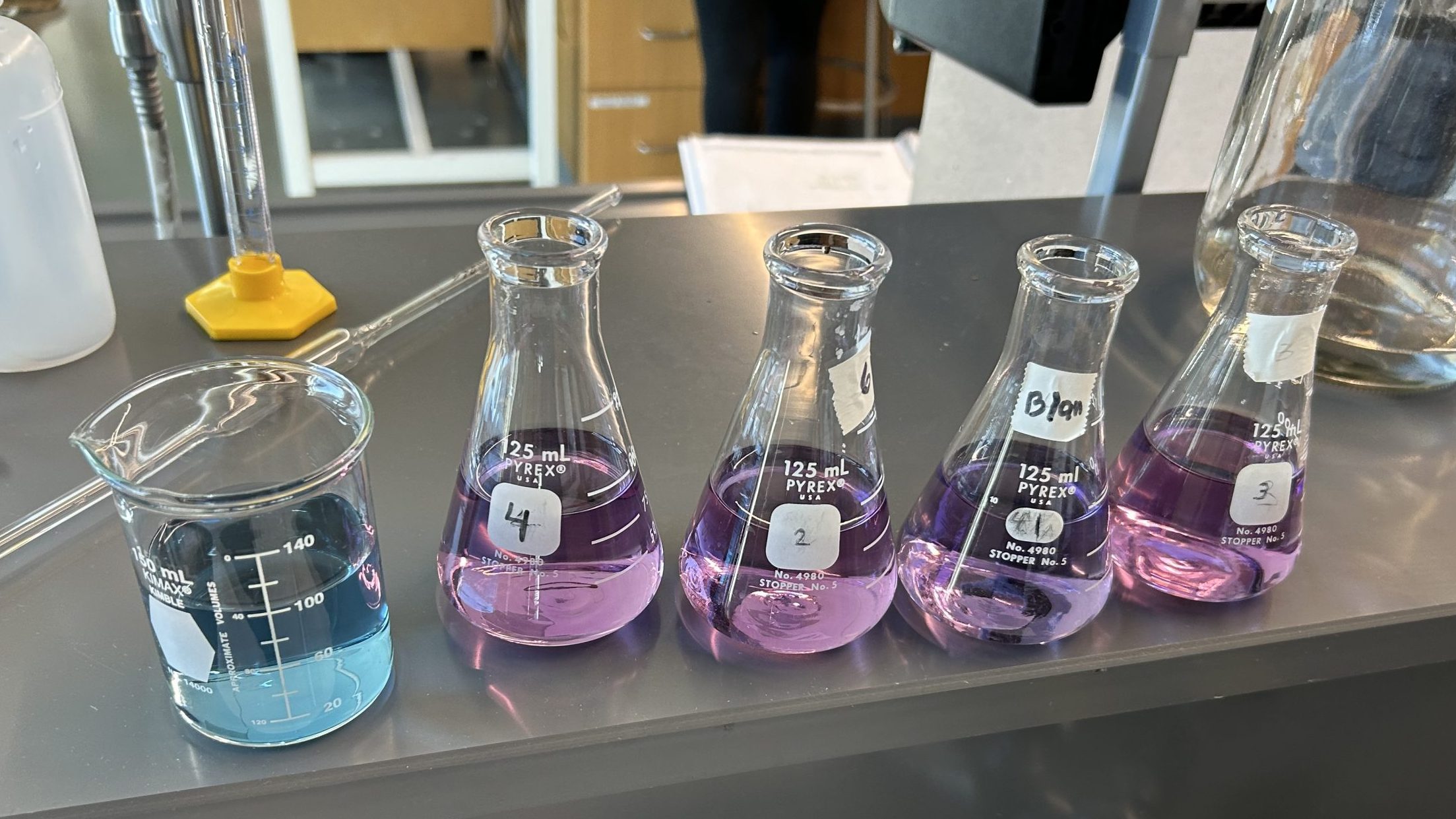 Chemistry beakers in the blab with bright color liquids.