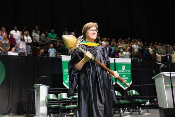 Susan K. Michael holds the mace on stage at UNC Charlotte's graduation.