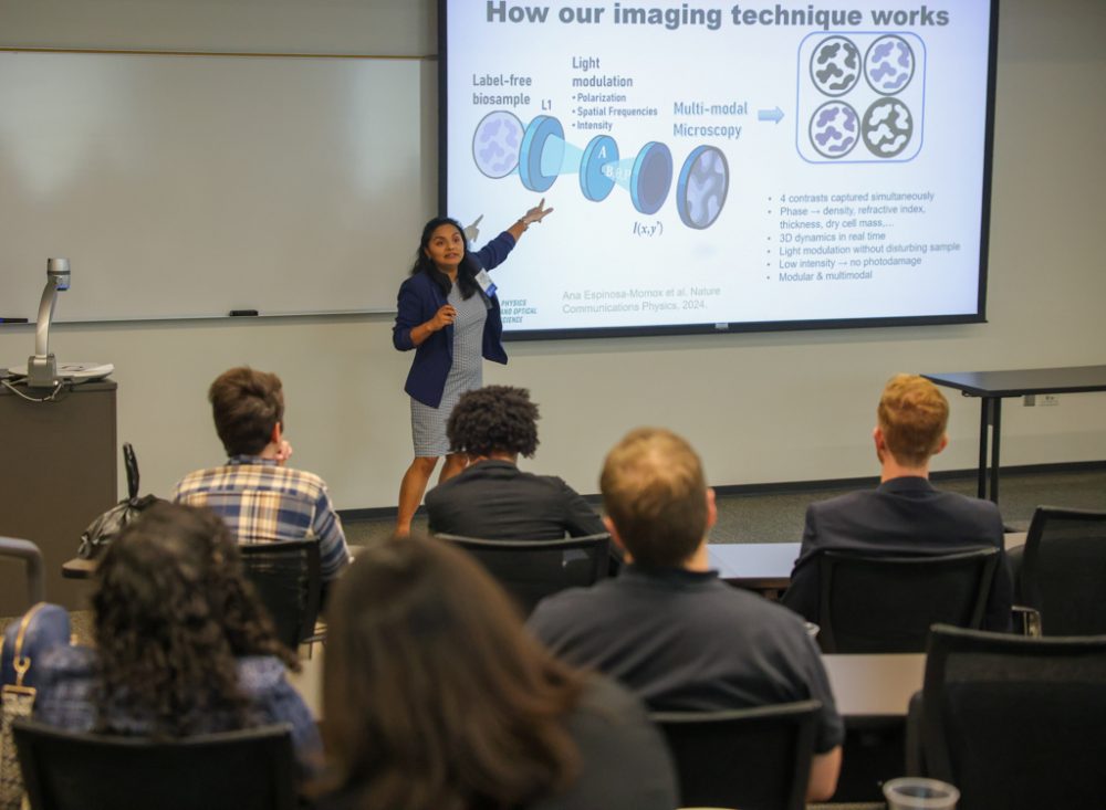 Associate Professor Rosario Porras-Aguilar points to her powerpoint presentation while speaking to an audience