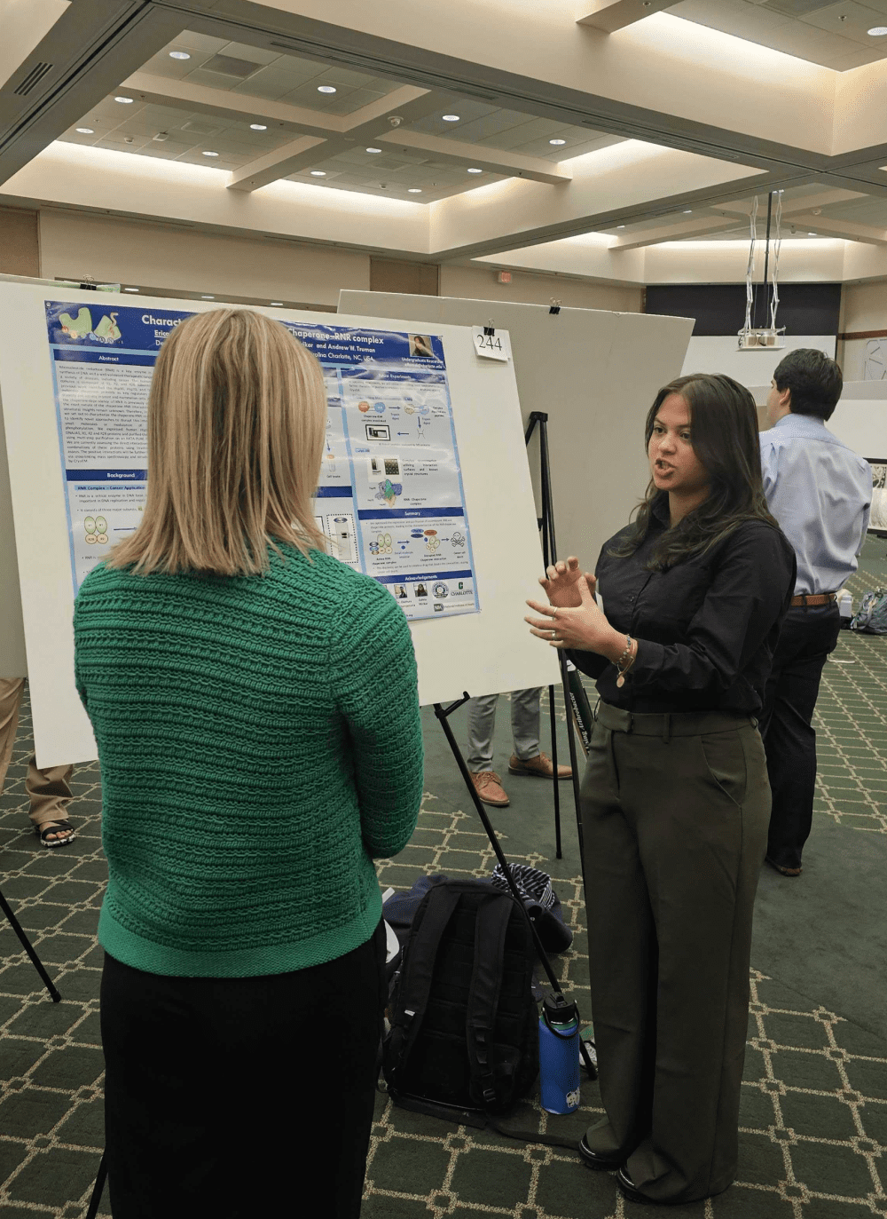 Flores presenting her poster to an attendee at the 2024 Biological Sciences Research Symposium