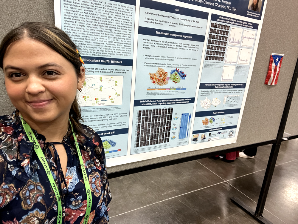 Flores taking a selfie of her poster at the 2024 SACNAS conference
