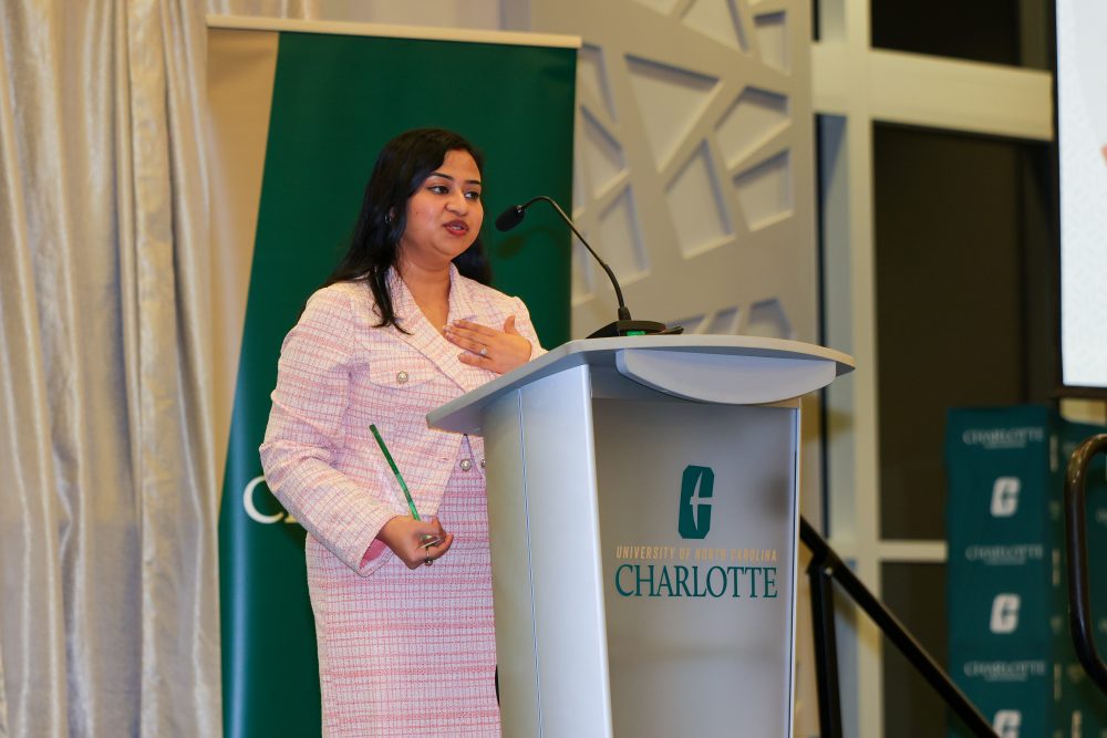 Mukulika Bose speaks at the UNC Charlotte podium while holding her award. 