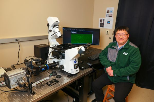 UNC Charlotte's Irwin Belk Dinsguished Scholar of Biology, Xiaojun Ren, with the ultra‑sensitive live-cell single‑molecule microscope.
