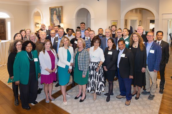 A large group of people standing inside the UNC Charlotte Bissell House, smiling for the camera.