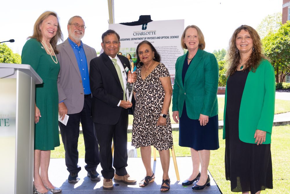 6 people on a stage outside in the courtyard near Grigg Hall at UNC Charlotte.
Chancellor Sharon Gaber, Glenn Boreman, Ishwar and Shail Aggarwal, Provost Jennifer Troyer and Klein College of Science Dean Bernadette Donovan-Merkert.