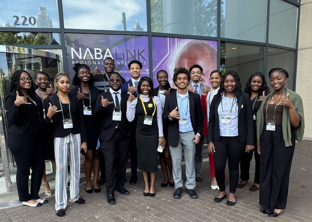 Ntasin posing outside a building in Atlanta with 14 additional NABA participants.