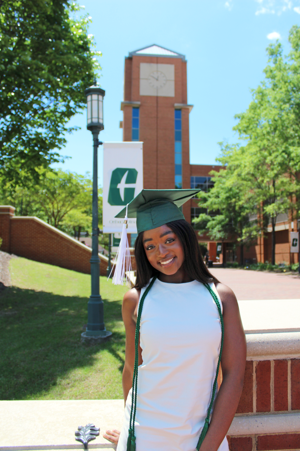 Ntasin poses in front of the UNC Charlotte clock tower outside the James H. Barnhardt Student Activity Center (SAC) and Halton Arena.