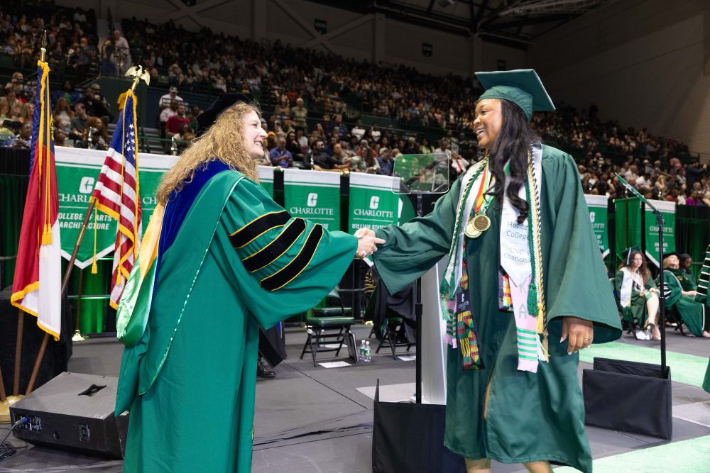 Klein College of Science Dean Bernadette Donovan-Merkert shakes the hand of Arielle Brown as she crosses the stage.