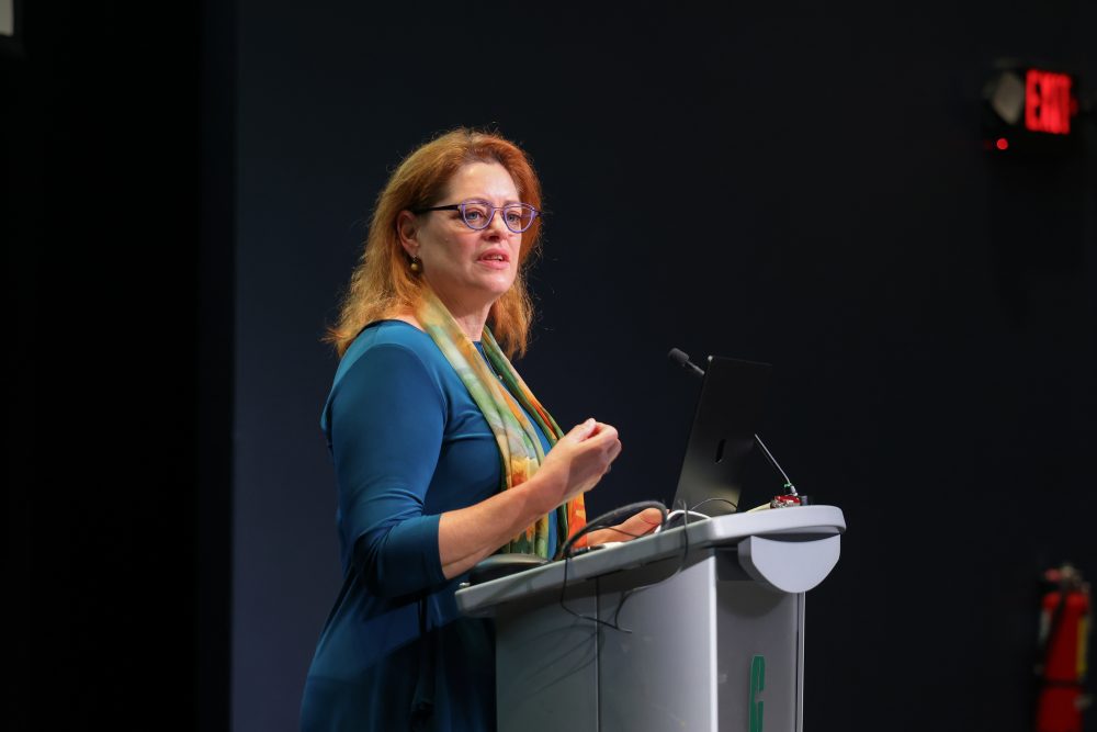 A close up of Deborah Thomas presenting on stage.