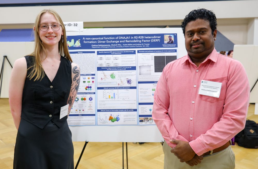Riley and Paththamperuma pose in front of their poster.