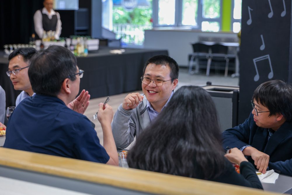Attendees smile and laugh at a table during the networking event.