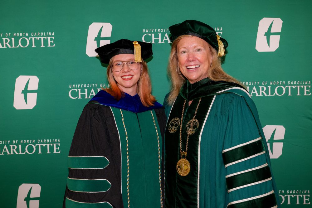 Hal West-Page, three time UNC Charlotte graduate, poses with UNC Charlotte Chancellor Sharon L. Gaber before the August 2026 commencement ceremony.