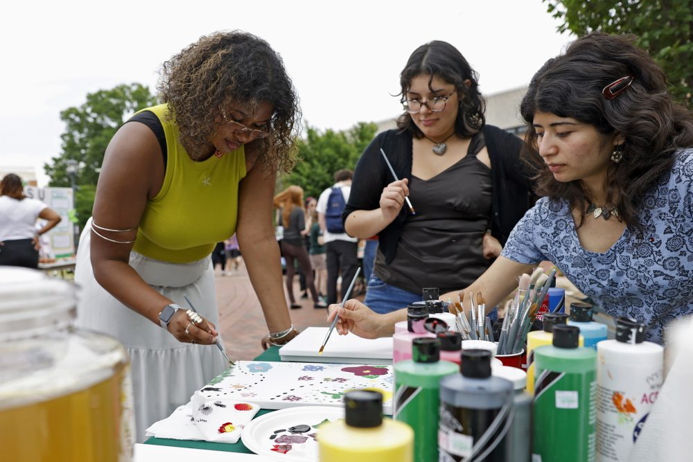 Zarah Rahman Blythe, biology major in the UNC Charlotte Klein College of Science, paints at a table with other student organization members during the Party for the Planet event.