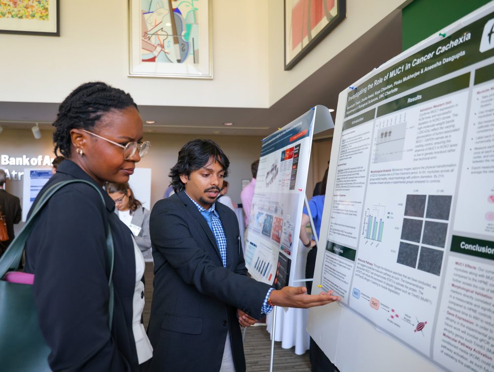 UNC Charlotte Dasgupta Lab member Kaustubh Tiwari presents his scientific poster presentation on cancer cachexia to an attendee of the Biomedical Sciences Symposium.