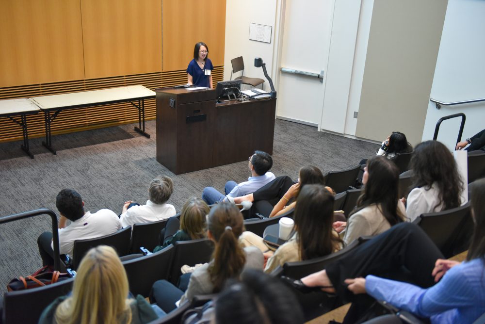 Youjun Wu, postdoc researchers in the Mukherjee lab, speaks to an audience in the Dubois Center lecture hall for "Activation of Interferon-Gamma Signaling Sensitizes Pancreatic Cancer Cells to Chemotherapy," at the 2026 Biomedical Sciences Symposium.